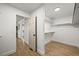 A walk-in closet with hardwood floors, white walls and shelving provides ample storage space at 1896 S Marshall Cir, Lakewood, CO 80232