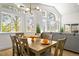 Bright dining space with hardwood floors, stylish lighting, and large windows overlooking a lush landscape at 1896 S Marshall Cir, Lakewood, CO 80232