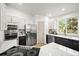 Modern kitchen featuring white cabinets, stainless steel appliances, and a sleek island cooktop at 1896 S Marshall Cir, Lakewood, CO 80232