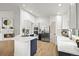Bright kitchen featuring white cabinets, stainless steel appliances, a large island, and a cozy fireplace nearby at 1896 S Marshall Cir, Lakewood, CO 80232