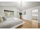 Sun-filled main bedroom boasts hardwood floors and a view of the outdoors, with an ensuite bathroom just beyond the door at 1896 S Marshall Cir, Lakewood, CO 80232