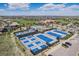 Aerial view showcasing a community clubhouse, pool, tennis courts, and ample parking space at 26004 E Elmhurst Pl, Aurora, CO 80016