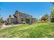 Exterior view of a home featuring a covered patio and spacious landscaped backyard at 26004 E Elmhurst Pl, Aurora, CO 80016