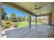 Spacious covered backyard patio with ceiling fans overlooking a well-maintained yard and garden at 26004 E Elmhurst Pl, Aurora, CO 80016