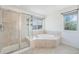 Elegant bathroom with a standalone shower and large soaking tub with natural light from two windows at 26004 E Elmhurst Pl, Aurora, CO 80016