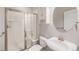 Well-lit bathroom with a stand-up shower featuring glass doors, a vanity, and a storage cabinet at 26004 E Elmhurst Pl, Aurora, CO 80016