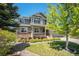 Beautiful two-story home with stone accents, a covered porch, and lush landscaping at 26004 E Elmhurst Pl, Aurora, CO 80016