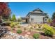 Backyard view of two-story house with garden beds and a covered patio, enhancing the property's outdoor living space at 26004 E Elmhurst Pl, Aurora, CO 80016