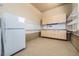 Well-organized garage area with storage cabinets, pegboard, and a clean refrigerator for added convenience at 26004 E Elmhurst Pl, Aurora, CO 80016