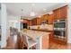 Bright kitchen featuring stainless steel appliances, granite countertops, wood floors, and a center island with barstool seating at 26004 E Elmhurst Pl, Aurora, CO 80016