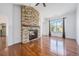 Inviting living room featuring a stone fireplace, hardwood flooring, and bright natural light from the large windows at 26004 E Elmhurst Pl, Aurora, CO 80016