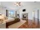 Main bedroom featuring hardwood floors, vaulted ceiling, fireplace, and natural light from the window at 26004 E Elmhurst Pl, Aurora, CO 80016