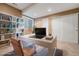 Cozy home office with built-in bookshelves, a sleek white desk, and plenty of natural light at 26004 E Elmhurst Pl, Aurora, CO 80016