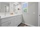 Elegant bathroom featuring double sinks with white countertops and a bright window offering natural light at 5272 W Capri Pl, Littleton, CO 80123