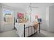 Well-lit bedroom with a black metal bed frame, colorful pillows, and large windows overlooking the neighborhood at 5272 W Capri Pl, Littleton, CO 80123