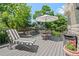 Relaxing outdoor deck with comfortable seating, umbrella, and grill, surrounded by lush greenery at 5272 W Capri Pl, Littleton, CO 80123