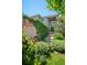 Inviting front entrance with lush landscaping, including colorful flowers and mature trees, leading to a charming covered porch at 5272 W Capri Pl, Littleton, CO 80123