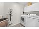 Well-equipped laundry room with modern washer, dryer, storage cabinets, and wash basin at 5272 W Capri Pl, Littleton, CO 80123