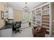 Comfortable office space with custom built-ins, a desk, chair, and natural light from a window at 5272 W Capri Pl, Littleton, CO 80123