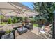 Charming stone patio features stylish seating, a modern fire pit, and views of the landscaped backyard at 5272 W Capri Pl, Littleton, CO 80123