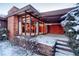 Covered patio area with brick walls and winter scene at 5420 Manitou Rd, Littleton, CO 80123