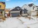 Two-story house with gray siding and stone accents, a two-car garage, and a partially snow-covered front yard at 3361 N Buchanan Way, Aurora, CO 80019