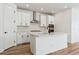 Modern kitchen with white cabinets, stainless steel appliances, and a large island at 3361 N Buchanan Way, Aurora, CO 80019