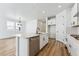 White kitchen with island, stainless steel appliances, and hardwood floors at 3361 N Buchanan Way, Aurora, CO 80019