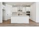 Modern kitchen featuring white cabinets, stainless steel appliances, and a large kitchen island at 3361 N Buchanan Way, Aurora, CO 80019