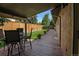 Outdoor deck with seating, overlooking a well-manicured lawn with privacy fence and lush greenery at 6223 W Flora Pl, Denver, CO 80227