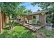 Charming backyard deck with outdoor seating and dining area, surrounded by lush greenery at 6223 W Flora Pl, Denver, CO 80227