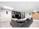 Finished basement features a carpeted open area with a sectional couch and a entertainment system at 6223 W Flora Pl, Denver, CO 80227