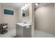Simple bathroom with modern sink and storage, bright lighting, and neutral tones at 6223 W Flora Pl, Denver, CO 80227