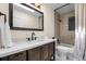 Stylishly renovated bathroom with modern fixtures, quartz counters, and tiled shower at 6223 W Flora Pl, Denver, CO 80227