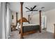 A spacious primary bedroom featuring a decorative four poster bed, plush carpet and neutral paint at 6223 W Flora Pl, Denver, CO 80227