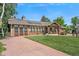 Inviting home featuring a brick and stucco facade, covered porch, and well-maintained front lawn at 6223 W Flora Pl, Denver, CO 80227