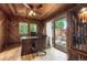 A traditionally styled wood paneled home office with an executive desk and an adjacent view to a relaxing outdoor space at 6223 W Flora Pl, Denver, CO 80227