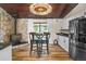 Open kitchen with eat-in nook, stone fireplace, and stainless appliances at 6223 W Flora Pl, Denver, CO 80227