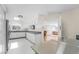 Bright white kitchen with skylight and stainless steel appliances at 6223 W Flora Pl, Denver, CO 80227