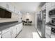 Long kitchen with stainless appliances and white cabinets at 6223 W Flora Pl, Denver, CO 80227