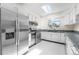 White kitchen with stainless appliances and eat-in area at 6223 W Flora Pl, Denver, CO 80227