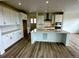 Bright kitchen featuring an island with countertop, white cabinets and modern appliances at 13358 Blue Amber Ct, Parker, CO 80134