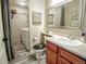 Bathroom featuring wood vanity, toilet, mirror and a shower/laundry area with washer and dryer at 1427 Deerwood Dr, Longmont, CO 80504