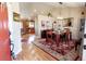 Open dining room with wood floors, stylish rug, and an open view of the updated kitchen at 1427 Deerwood Dr, Longmont, CO 80504