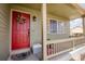 Inviting front porch with a charming red door, adorned with a wreath and a 'No Soliciting' sign at 1427 Deerwood Dr, Longmont, CO 80504