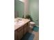 Cozy bathroom with light green walls, and a well-maintained sink, and toilet at 559 Alton Way # C, Denver, CO 80230