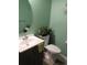 Cozy bathroom featuring a rounded mirror, green walls, and a white toilet with a plant at 559 Alton Way # C, Denver, CO 80230