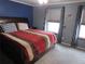 Comfortable bedroom with a blue accent wall and two windows with patterned curtains at 559 Alton Way # C, Denver, CO 80230