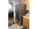 Modern stainless steel refrigerator in kitchen with wooden cabinets and tile backsplash at 559 Alton Way # C, Denver, CO 80230