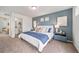 Comfortable bedroom with blue accent wall, large bed, and ensuite bathroom at 13029 E 103Rd Pl, Commerce City, CO 80022